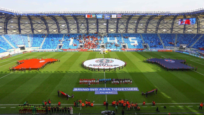 Football stadium in Dubai during an international tournament with teams lined up on the pitch