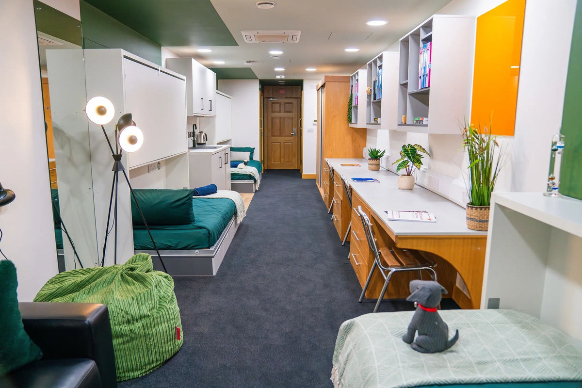 Modern shared boarding room at a UK boarding school, with beds, study desks and shelves